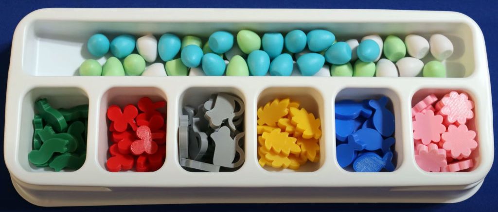 Plastic game components including eggs, rats, fruit from the game Wingspan.