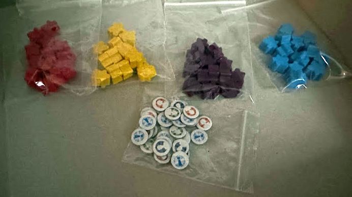 Mini meeples in four colors, each in a plastic bag
