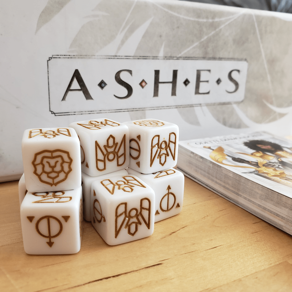 Divine Magic dice in foreground; Ashes box in background.