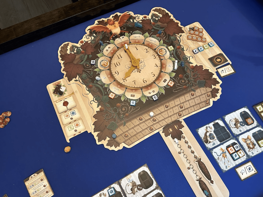 Hickory Dickory board game on a blue game mat. Board shows a large clock, side board, and clock chain with some mouse cards and tiles off to the side.