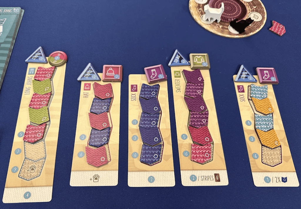 Knitting Circle game: front of the garment board with yard tiles and button tokens shown. 