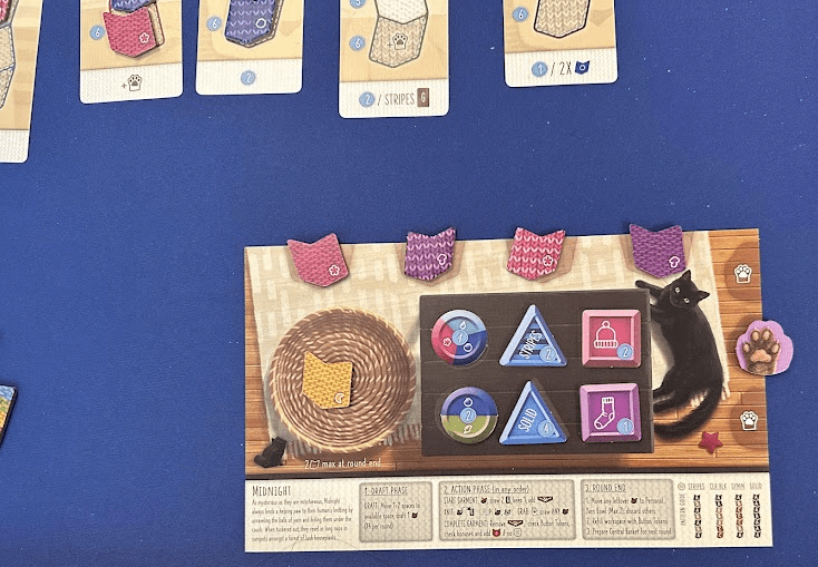 Player board with yarn tokens, button tokens, and cat paw token.