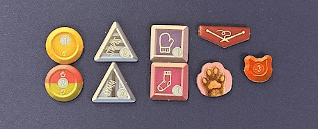 Close up of button, knitting needle, cat pay, and cat head tokens.