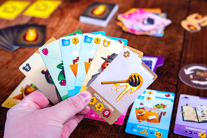 Hand holding 6 cards. The one easiest to read is Honey Dipper.